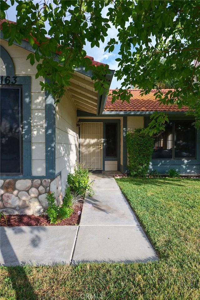 view of exterior entry featuring a yard