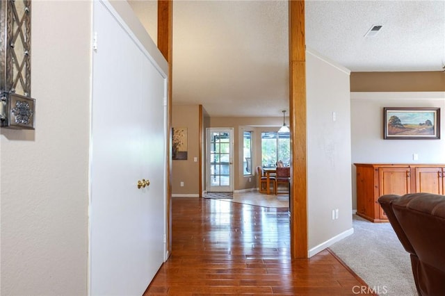 hallway with a textured ceiling and hardwood / wood-style flooring