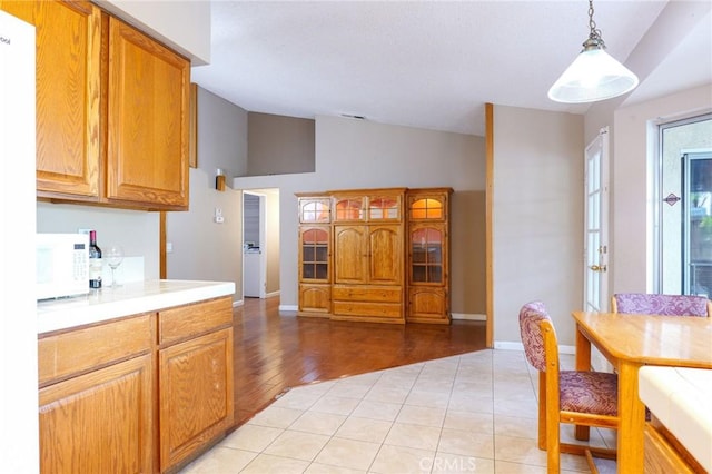 kitchen featuring lofted ceiling, light hardwood / wood-style floors, and decorative light fixtures