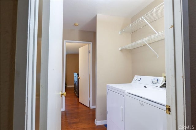 laundry area with washing machine and dryer and dark wood-type flooring