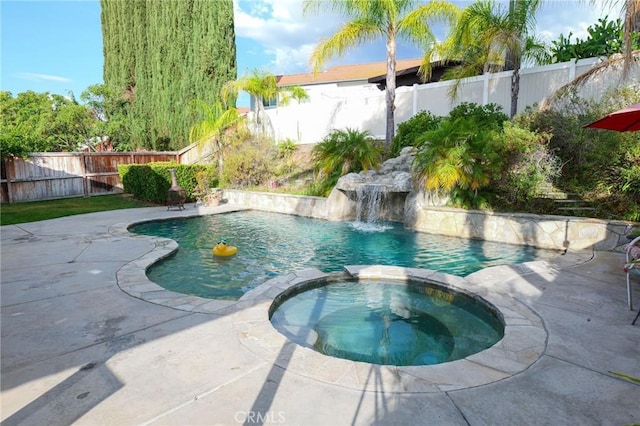 view of pool featuring an in ground hot tub, pool water feature, and a patio