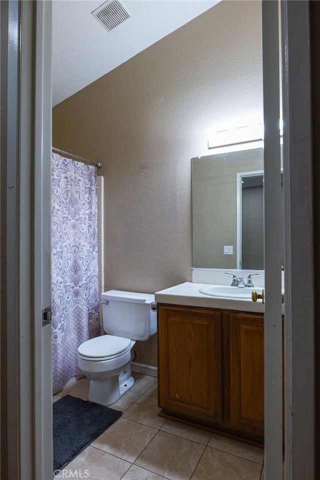 bathroom featuring tile patterned flooring, vanity, and toilet