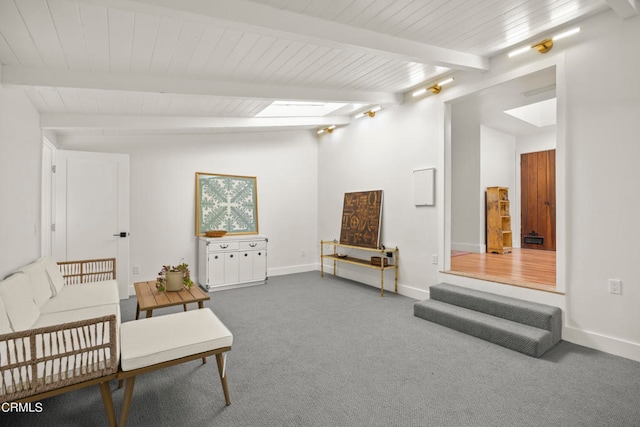 sitting room featuring a skylight, beam ceiling, and carpet flooring