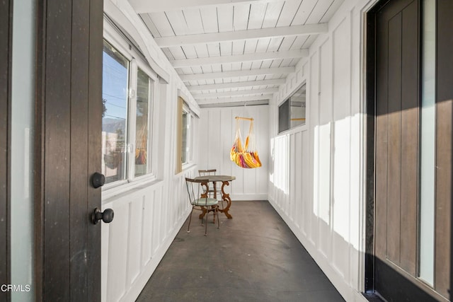 sunroom / solarium featuring beamed ceiling, wood ceiling, and plenty of natural light