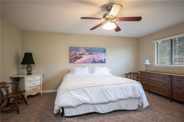 bedroom featuring ceiling fan and dark carpet