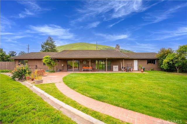 back of property featuring a patio area and a lawn