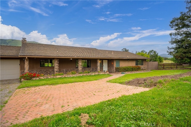 ranch-style house featuring a garage and a front yard