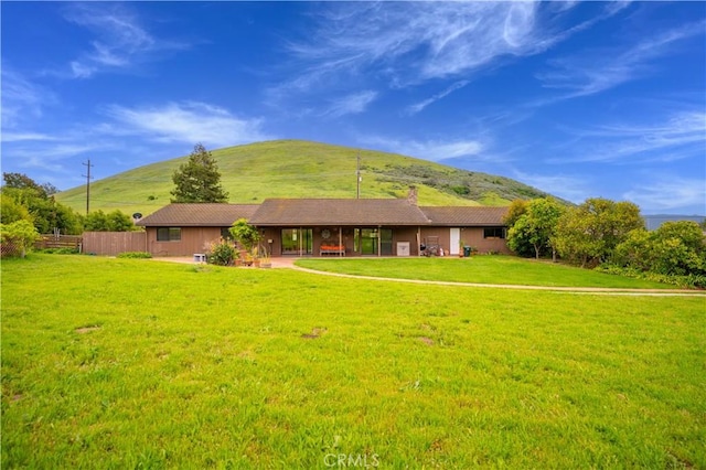 single story home with a mountain view and a front lawn