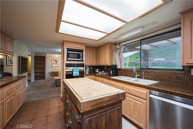 kitchen with tasteful backsplash, appliances with stainless steel finishes, sink, and a kitchen island