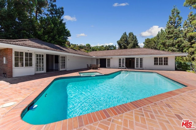 view of pool with an in ground hot tub and a patio area