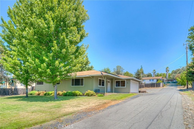 single story home featuring a garage and a front lawn