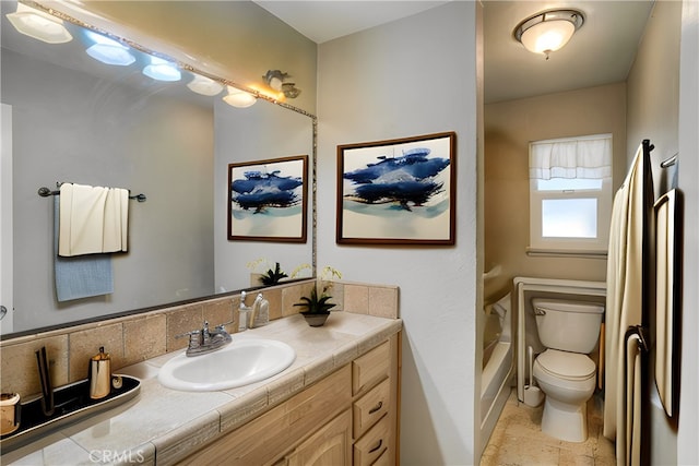 bathroom featuring vanity, a bathtub, and toilet