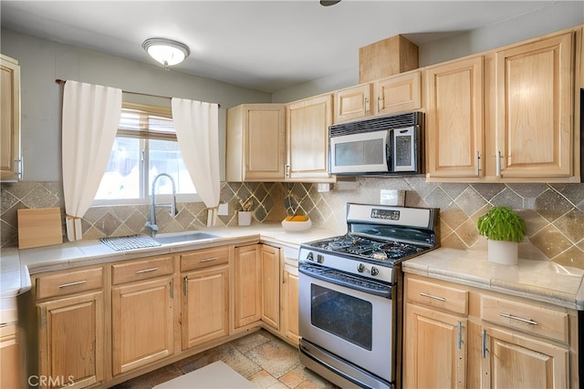 kitchen with stainless steel appliances, sink, and backsplash