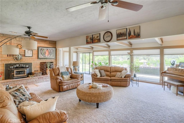 living room featuring ceiling fan, carpet flooring, a textured ceiling, and a fireplace