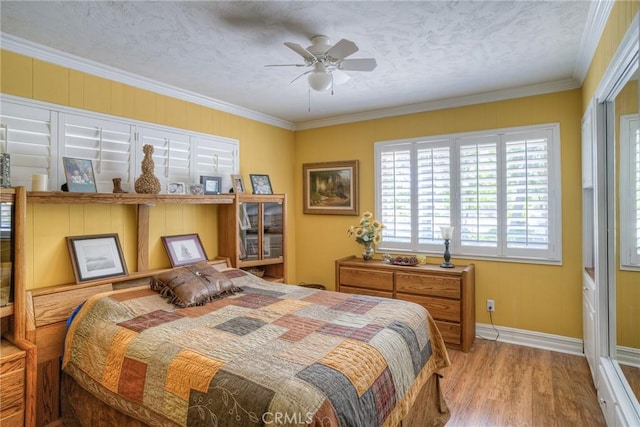 bedroom with ornamental molding, a textured ceiling, and light wood-type flooring