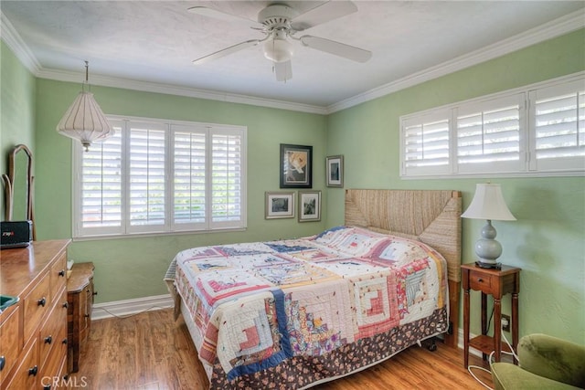 bedroom featuring hardwood / wood-style floors, crown molding, and ceiling fan