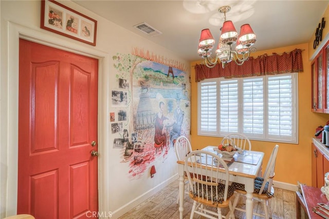 dining area with a chandelier and light hardwood / wood-style flooring