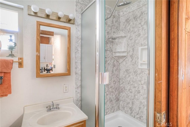 bathroom with vanity and a shower with door