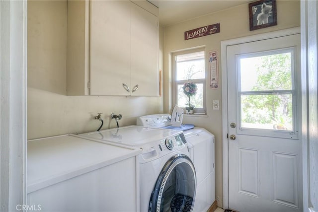 washroom featuring washer and clothes dryer, plenty of natural light, and cabinets