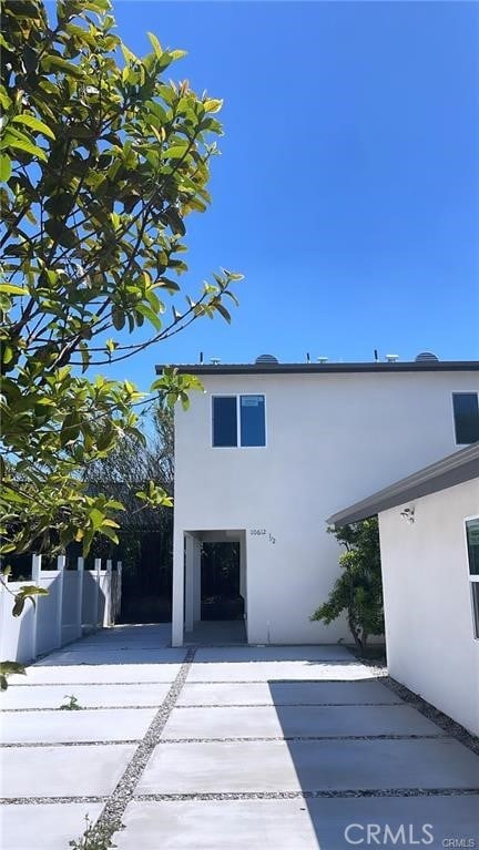 exterior space featuring fence, a patio, and stucco siding