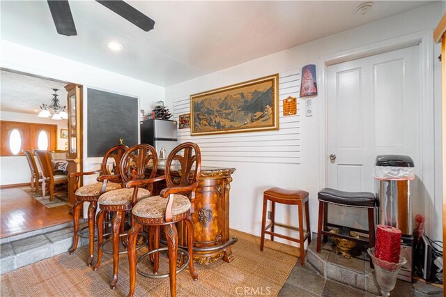 dining room featuring ceiling fan with notable chandelier