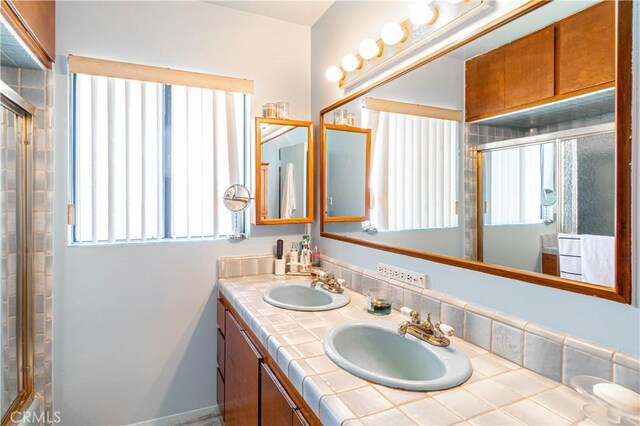 bathroom with an enclosed shower, vanity, and a wealth of natural light