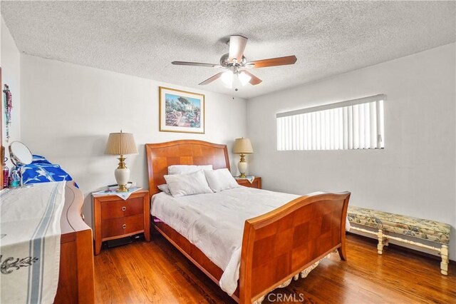 bedroom featuring hardwood / wood-style floors, ceiling fan, and a textured ceiling