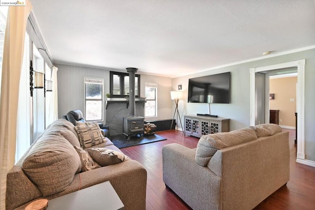 living room with dark wood-type flooring, a wood stove, and ornamental molding