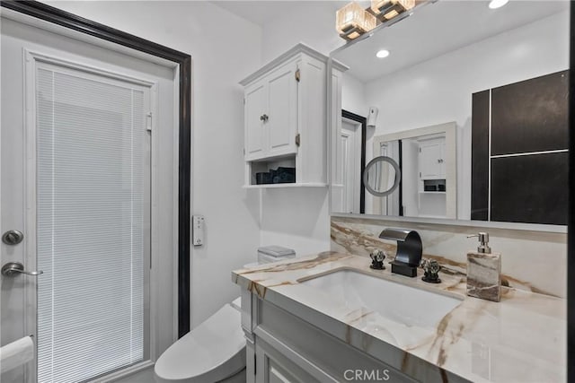 bathroom with recessed lighting, vanity, and toilet