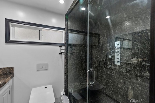 full bathroom featuring vanity, a marble finish shower, and toilet