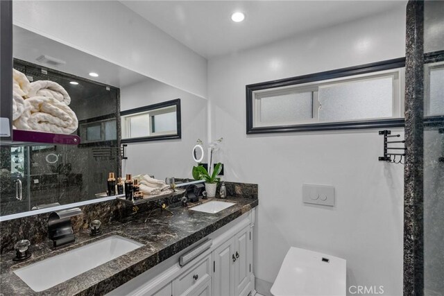 full bathroom featuring a sink, a stall shower, and double vanity