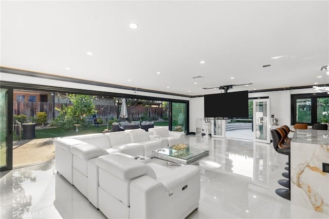 living room featuring recessed lighting, ornamental molding, and plenty of natural light