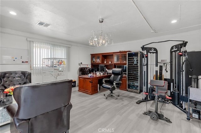 office space with an inviting chandelier, a textured ceiling, and light hardwood / wood-style flooring