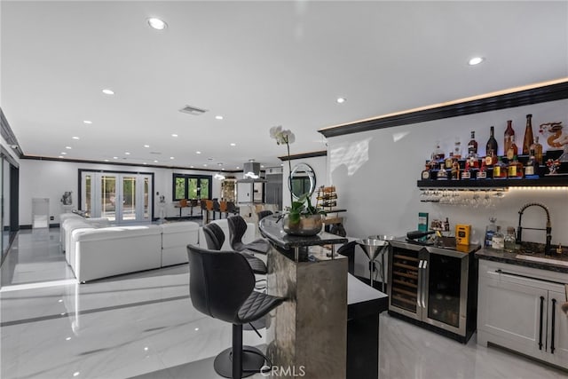 bar featuring crown molding, beverage cooler, and sink