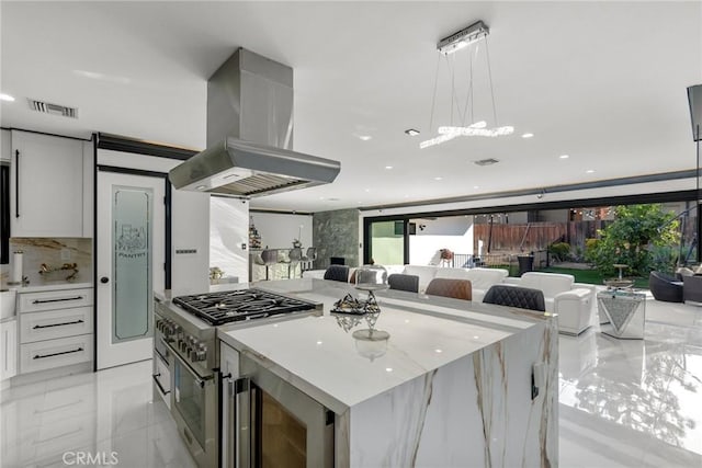 kitchen with exhaust hood, white cabinets, visible vents, and high end stainless steel range oven