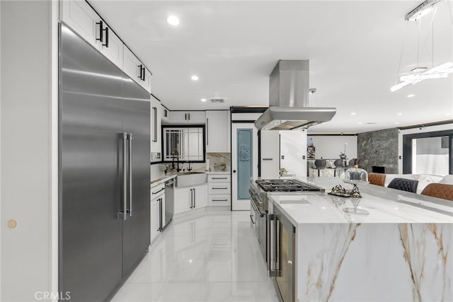 kitchen featuring island range hood, premium appliances, sink, and white cabinets