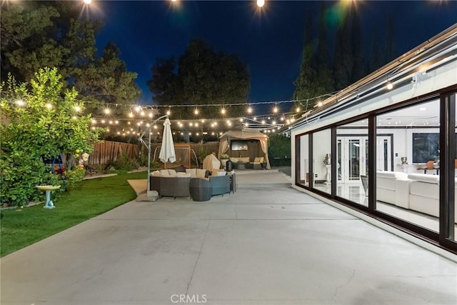 patio at twilight with fence, an outdoor hangout area, a yard, and french doors