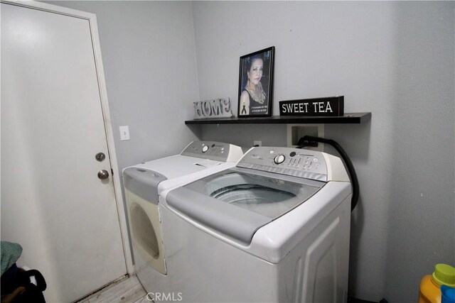 laundry room featuring independent washer and dryer and light hardwood / wood-style flooring