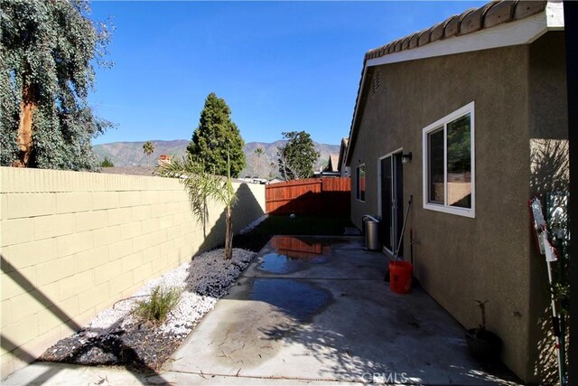 view of side of property featuring a mountain view and a patio