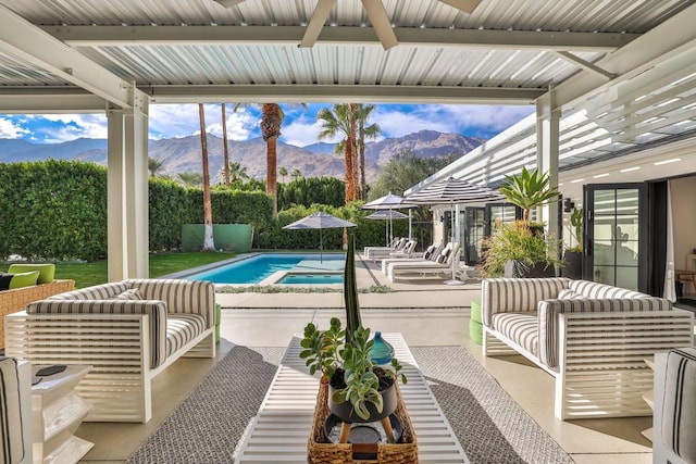 view of swimming pool with a patio, an outdoor living space, a gazebo, and a mountain view