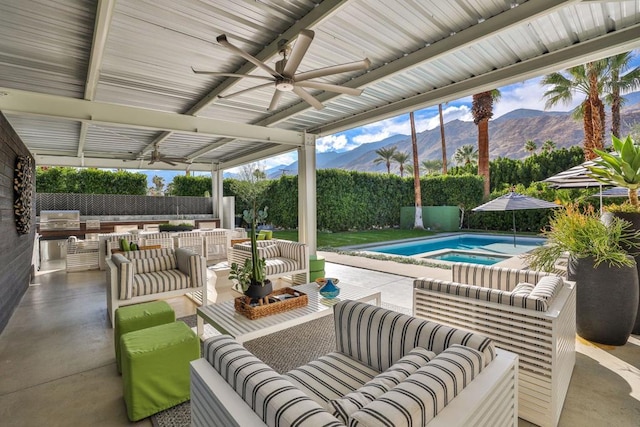 view of patio / terrace with ceiling fan, a fenced in pool, a mountain view, and outdoor lounge area