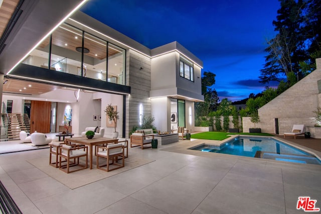 rear view of house featuring a swimming pool with hot tub and a patio area