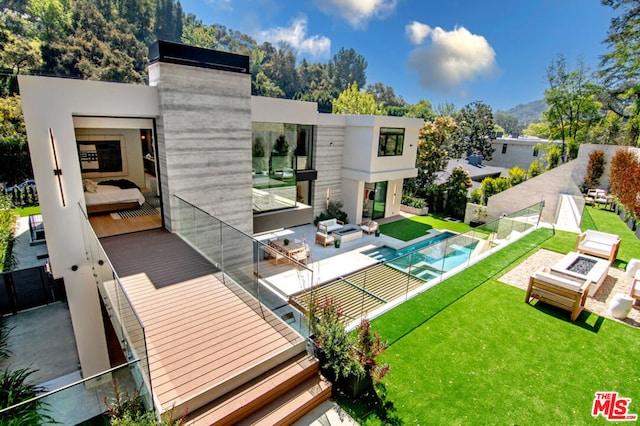 rear view of property with a fenced in pool, a lawn, outdoor lounge area, and a patio