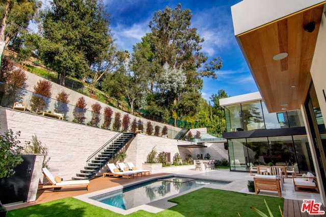 view of swimming pool with a lawn and a patio