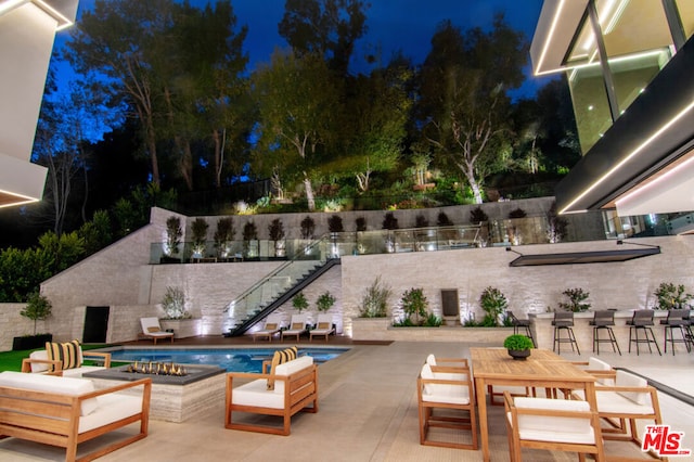 pool at twilight with a patio area