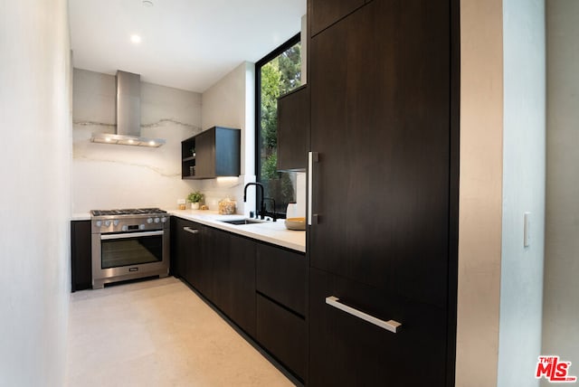 kitchen with tasteful backsplash, wall chimney range hood, sink, and gas stove