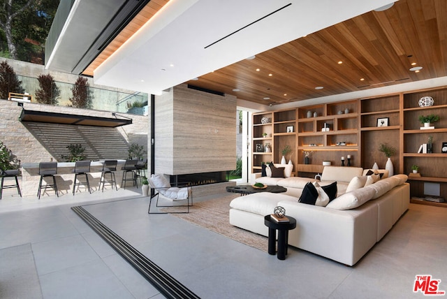 tiled living room with wood ceiling and a large fireplace