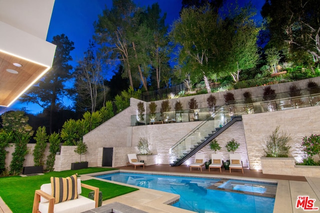 pool at twilight featuring a patio