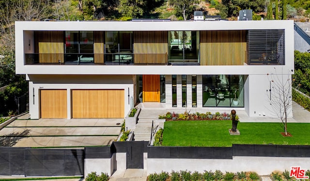 contemporary house featuring a front lawn and a garage