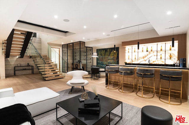 living room featuring bar and light wood-type flooring